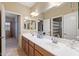 Bathroom with dual sinks, large mirror, and views to other rooms in the home at 18432 W Port Royale Ln, Surprise, AZ 85388