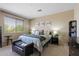 Cozy bedroom features comfortable bed, soft light, and modern decor, creating a relaxing private space at 18432 W Port Royale Ln, Surprise, AZ 85388