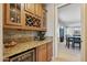 Butler pantry features granite counters, wine fridge, and storage for glasses and wine bottles at 18432 W Port Royale Ln, Surprise, AZ 85388