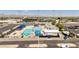 Aerial view of a vibrant community pool area with waterslides, seating, and recreational facilities for residents at 18432 W Port Royale Ln, Surprise, AZ 85388