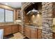 A kitchen featuring stone archway, stainless steel hood, granite counters, and wood cabinetry at 18432 W Port Royale Ln, Surprise, AZ 85388