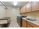 Functional laundry room with modern washer and dryer, storage, and ample counter space at 18432 W Port Royale Ln, Surprise, AZ 85388