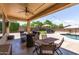 Backyard view with a covered patio, in-ground pool, umbrellas, and lounge chairs at 18432 W Port Royale Ln, Surprise, AZ 85388