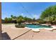 Backyard view with an in-ground pool, patio, umbrellas, and lounge chairs at 18432 W Port Royale Ln, Surprise, AZ 85388