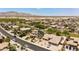 Aerial view of homes with desert landscaping, solar panels, and community in the background at 18432 W Port Royale Ln, Surprise, AZ 85388