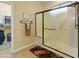 Bathroom showcasing a glass-enclosed shower, neutral walls, and an adjacent walk-in closet for storage at 18634 N Paloma Ct, Surprise, AZ 85387