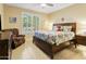 Serene bedroom with a wooden bed, window shutters, a cozy armchair, and a side table with a lamp at 18634 N Paloma Ct, Surprise, AZ 85387