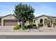 Charming single-story home with well-manicured landscaping, desert rock, and a mature shade tree at 18634 N Paloma Ct, Surprise, AZ 85387
