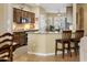 Inviting kitchen with granite countertops, wood cabinets, and a breakfast bar with seating at 18634 N Paloma Ct, Surprise, AZ 85387