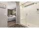 Modern bathroom featuring a glass-enclosed shower with a built-in seat, complemented by a view into the bedroom at 1882 S Jesse Pl, Chandler, AZ 85286