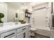 Bright bathroom featuring a tub with tile surround, sleek vanity, decorative shelf, and wood-look tile flooring at 1882 S Jesse Pl, Chandler, AZ 85286