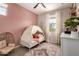 Charming bedroom features a whimsical canopy bed, soft pink accents, and a cozy rattan chair at 1882 S Jesse Pl, Chandler, AZ 85286