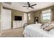 Serene bedroom with a dresser and mounted TV, complemented by a cozy bed and natural light at 1882 S Jesse Pl, Chandler, AZ 85286