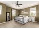 Cozy bedroom featuring a black metal bed frame, neutral decor, and ample natural light from the windows at 1882 S Jesse Pl, Chandler, AZ 85286