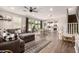 Open-concept living space with wood floors, a modern fan, and seamless flow to the kitchen and dining area at 1882 S Jesse Pl, Chandler, AZ 85286