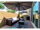 Inviting patio featuring stylish outdoor furniture, shade umbrellas, and a well-maintained brick surface at 1882 S Jesse Pl, Chandler, AZ 85286