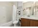 Cozy bathroom with a shower-tub combo, modern geometric decor, and wood-style vanity at 1887 W Periwinkle Way, Chandler, AZ 85248