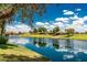 Picturesque pond surrounded by green grass and mature trees, enhancing the community's serene atmosphere at 1887 W Periwinkle Way, Chandler, AZ 85248