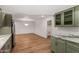 Kitchen and living room featuring light hardwood floors, modern green cabinets, and stainless steel appliances at 19013 N 18Th Ave, Phoenix, AZ 85027