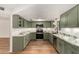 Modern kitchen featuring stainless steel appliances, marble countertops, green cabinets, and recessed lighting at 19013 N 18Th Ave, Phoenix, AZ 85027