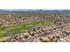Expansive aerial view of homes lining a lush green golf course with a pond and mountain views in the background at 19530 N 84Th Ave, Peoria, AZ 85382