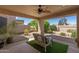 Covered patio with seating surrounded by a beautifully landscaped backyard at 19530 N 84Th Ave, Peoria, AZ 85382
