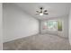 Spacious carpeted bedroom featuring a ceiling fan and natural light from large windows at 19530 N 84Th Ave, Peoria, AZ 85382
