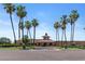 An inviting community entrance is surrounded by palm trees and desert landscaping at 19530 N 84Th Ave, Peoria, AZ 85382