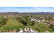 Picturesque aerial view overlooking a golf course community with ponds, lush fairways, and homes, all framed by mountain views at 19530 N 84Th Ave, Peoria, AZ 85382