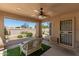 A covered patio area with a ceiling fan and seating offers a relaxing outdoor space at 19530 N 84Th Ave, Peoria, AZ 85382