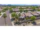 A neighborhood street with tile-roofed homes, desert landscaping, palm trees, and a decorative wall and community sign at 19530 N 84Th Ave, Peoria, AZ 85382