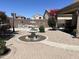 Beautiful backyard featuring a stone paved patio, elegant water fountain, mature trees and desert landscaping at 21873 W Pima St, Buckeye, AZ 85326