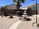 Beautiful backyard featuring a stone paved patio, elegant water fountain, mature trees and desert landscaping at 21873 W Pima St, Buckeye, AZ 85326
