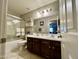 Bathroom features a double sink vanity with dark wood cabinets, shower with glass door, and neutral tiling at 21873 W Pima St, Buckeye, AZ 85326