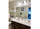 Bathroom features a double sink vanity with dark wood cabinets and coastal-themed decor accents at 21873 W Pima St, Buckeye, AZ 85326