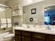 Bathroom features a double sink vanity with dark wood cabinets and coastal-themed decor at 21873 W Pima St, Buckeye, AZ 85326