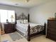 Bedroom features a decorative iron bed frame, neutral walls, plush carpet, and abundant natural light at 21873 W Pima St, Buckeye, AZ 85326