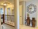 Upstairs hallway with decorative mirror, lighting, and access to other rooms in the home at 21873 W Pima St, Buckeye, AZ 85326