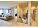 Bright living room with grey sofa, decorative mirror, and hallway access at 21873 W Pima St, Buckeye, AZ 85326