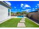 Lush backyard with artificial turf, elegant pavers, and a serene pool featuring a tranquil water feature at 2315 W Duane Ln, Phoenix, AZ 85085