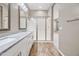 Light and bright bathroom featuring a double sink vanity with wood look floors and a step-in shower at 2315 W Duane Ln, Phoenix, AZ 85085