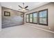 Open bedroom with tile accent wall, neutral carpet, ceiling fan, and views from the shuttered windows at 2315 W Duane Ln, Phoenix, AZ 85085