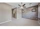 Light-filled bedroom with views to an en suite bath; features a ceiling fan and neutral carpet at 2315 W Duane Ln, Phoenix, AZ 85085