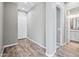 Inviting hallway with wood-style flooring leading to a bathroom with granite countertops and a white door at 2315 W Duane Ln, Phoenix, AZ 85085