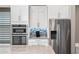 Modern kitchen features stainless steel appliances, white cabinets, and decorative backsplash at 2315 W Duane Ln, Phoenix, AZ 85085