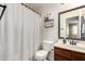 Neat bathroom featuring a toilet, vanity, mirror and shower with curtain at 23749 W Grove St, Buckeye, AZ 85326