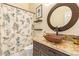 Bathroom features a copper vessel sink, decorative mirror and dark wood cabinets at 251 E Arabian Dr, Gilbert, AZ 85296