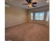 Spacious bedroom featuring a ceiling fan, large windows, and neutral carpeting at 26747 W Pontiac Dr, Buckeye, AZ 85396