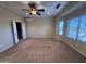Spacious bedroom with ceiling fan, large windows, and door leading into a closet at 26747 W Pontiac Dr, Buckeye, AZ 85396