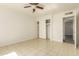 Bright bedroom featuring tiled floors, ceiling fan, white brick walls, and a sliding door closet at 2908 N 54Th Dr, Phoenix, AZ 85031